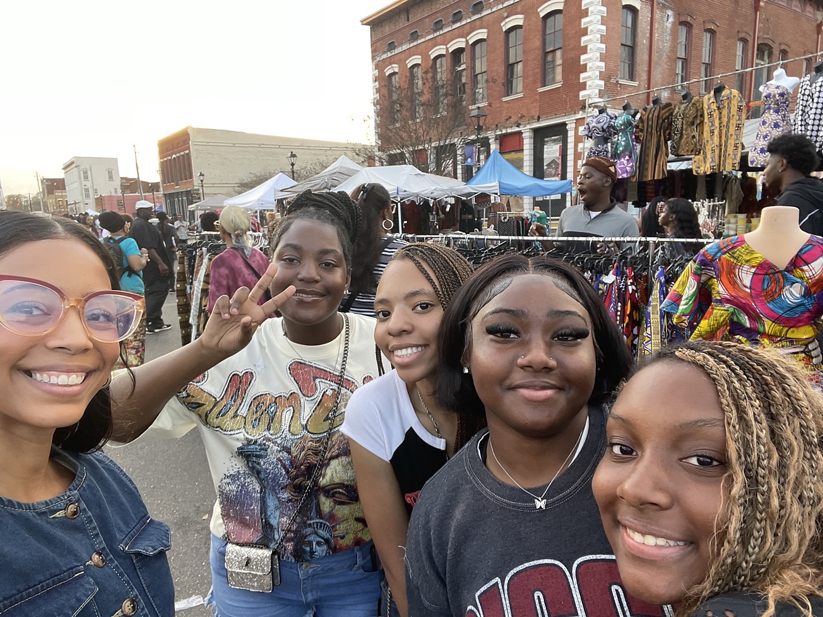Ella and a group of young women smiling together at a street market in downtown Selma