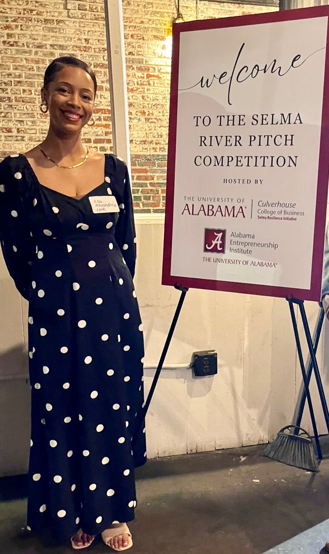 Ella Alexandria Love beside the welcome sign at the Selma River Pitch Competition