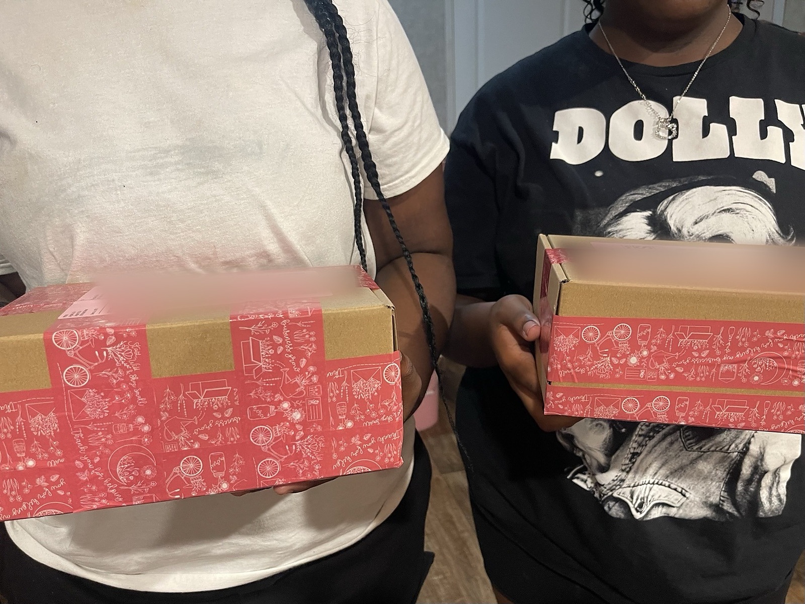 Two participants holding packed shipping boxes ready to send to customers
